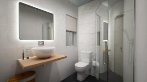 uma casa de banho com um lavatório, um WC e um espelho. em Gest em Mellieħa