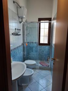 y baño con ducha, aseo y lavamanos. en Apartment Rose e Fiori Sardegna en San Vito