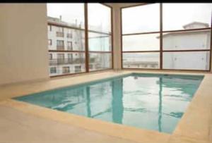 a large swimming pool in a building with windows at BlackBird Moreno1 in San Carlos de Bariloche