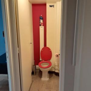 La salle de bains est pourvue de toilettes avec un mur rouge. dans l'établissement chambre dans une colocation, à Rennes