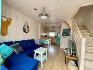 - un salon avec un canapé bleu et un escalier dans l'établissement Halo Dębki, à Dębki