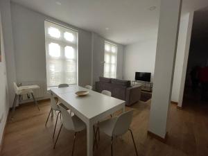 uma sala de estar com uma mesa branca e cadeiras em Apartamentos Turísticos Las Ánimas Comillas em Comillas