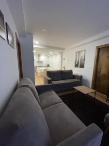 uma sala de estar com um sofá e uma mesa em Apartamentos Turísticos Las Ánimas Comillas em Comillas