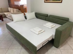 a green couch with two white pillows on it at Kisamos Nice Apartment 3 in Kissamos