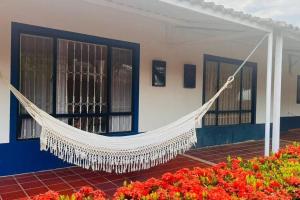 a hammock in front of a building with flowers at Grandiosa Casa-Jacuzzi Privado in Flandes