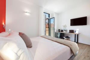 una camera con letto bianco e TV di YourHome - Lidia Rooms & Suites a Sorrento