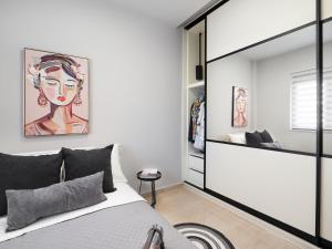 een slaapkamer met een bed en een grote spiegel bij The H Experience - Stylish 2BD apt with balcony in Heraklion center in Heraklion