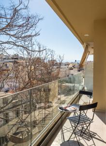 een balkon met 2 stoelen en uitzicht op de stad bij The H Experience - Stylish 2BD apt with balcony in Heraklion center in Heraklion