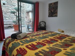 a bedroom with a bed with a colorful blanket on it at Loft vue montagne in Rigarda