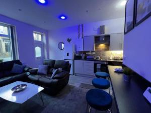een paarse woonkamer met een bank en een tafel bij Luxe Loft Living: A Home Away From Home in Wibsey
