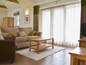 a living room with a couch and a table at Meillion Cottage in Letterston