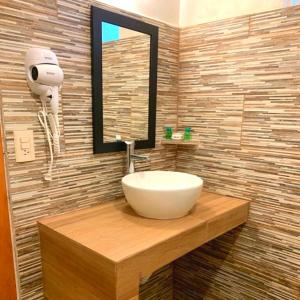 a bathroom with a white sink and a mirror at Hotel La Ceiba in Chiapa de Corzo