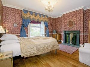 1 dormitorio con 1 cama y chimenea en Edderside Hall, en Mawbray