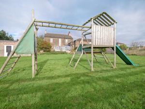 un columpio y una silla en un patio en Edderside Hall, en Mawbray