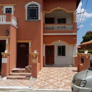 un edificio arancione con balcone e porta di Royal Vybez Vacation Homes a Spanish Town