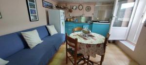 cocina pequeña con mesa y sofá azul en Sofi's House, en Ándros