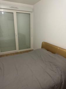 a bedroom with a bed and two windows with blinds at Myhotel19 in Noisy-le-Grand