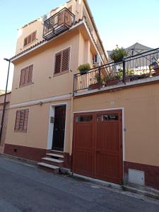 サン・ヴィートにあるAppartamento Ginepro Sardegnaのガレージドア2つとバルコニー付きの建物