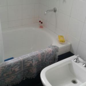 y baño con bañera y lavamanos. en La Posada de Agustina en Tandil