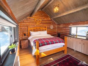 a bedroom with a bed in a log cabin at Chute Lake Lodge in Naramata