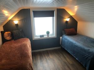 a small bedroom with a bed and a window at Lofoten and Vesterålen Kveldro in Myrland
