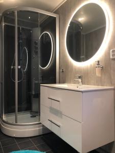 a bathroom with a sink and a shower with mirrors at Lofoten and Vesterålen Kveldro in Myrland