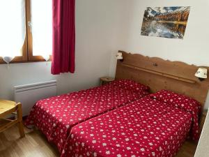 een slaapkamer met een bed met een rood dekbed bij Les granges d'Arvieux 701 in Arvieux