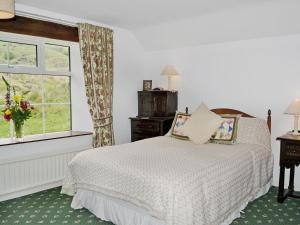 a bedroom with a bed and a window at Whistling Green in Ulpha