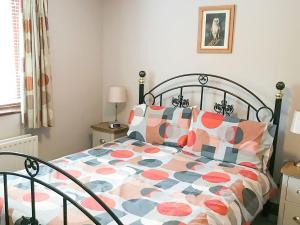 ein Schlafzimmer mit einem Bett mit einer bunten Bettdecke in der Unterkunft Heron in Welney