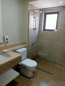 a bathroom with a toilet and a shower and a sink at Villa Fanadir, El Gouna in Hurghada