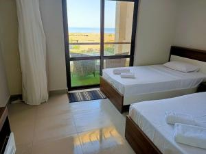 a room with two beds and a large window at Villa Fanadir, El Gouna in Hurghada