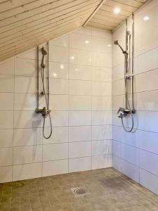 a bathroom with two shower heads and a wall at Otavalan ullakko in Tampere