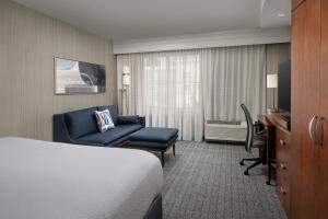 a hotel room with a bed and a chair and a desk at Courtyard by Marriott Seattle Kirkland in Kirkland