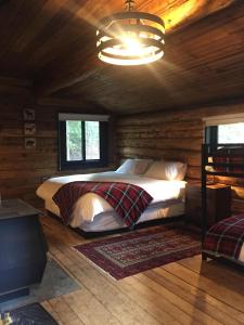a bedroom with a bed in a log cabin at Chute Lake Lodge in Naramata