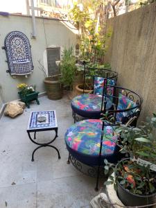 Lotem的住宿－פינה קסומה בהר，庭院设有两把椅子和一张桌子,种有植物