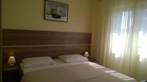 a bedroom with a bed and a window at Rooms & Apartments Blue Beach in Vodice