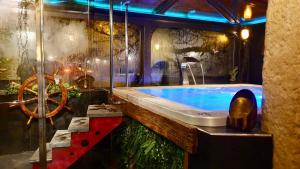 baño grande con bañera grande y ventana grande en HOTEL de la Truite & SPA Le petit Nautilus, en Le Pont