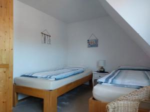 two twin beds in a room with a staircase at Voslapper Seeluft in Wilhelmshaven