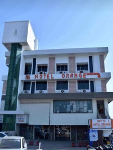 a hotel with a sign on the front of it at Hotel Orange in Vapi
