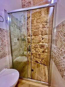y baño con ducha de cristal y aseo. en La Maison Arco Boccolicchio en Manfredonia