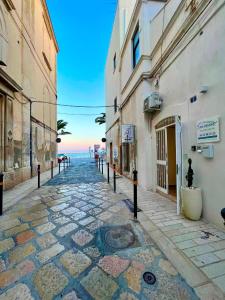 an empty street next to a building with the ocean at La Maison Arco Boccolicchio in Manfredonia