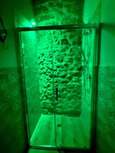 a glass shower in a room with a stone wall at La Maison Arco Boccolicchio in Manfredonia +33 photos