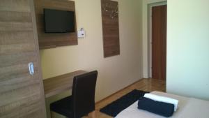a room with a desk and a chair and a television at Rooms & Apartments Blue Beach in Vodice