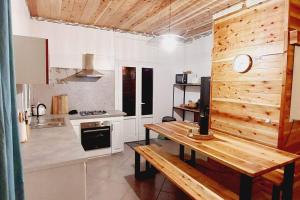 a kitchen with a wooden table and a wooden wall at Le Margousier in Cilaos