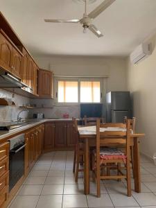 a kitchen with a wooden table and a table and chairs at Casa Fanù in Licata