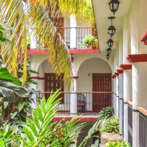 a courtyard of a house with a balcony and plants at Hotel La Ceiba in Chiapa de Corzo