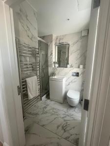 a white bathroom with a toilet and a sink at Stunning Marylebone apartment in London