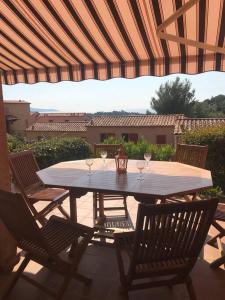 a table with three wine glasses on a patio at Appartement 1 chambre vue mer et grande terrasse in Cavalaire-sur-Mer