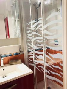 a bathroom with a shower with a sink and a mirror at Appartement 1 chambre vue mer et grande terrasse in Cavalaire-sur-Mer