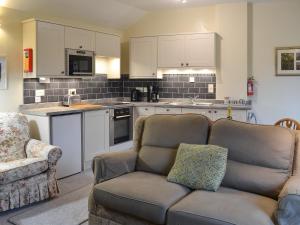 a living room with a couch and a kitchen at The Smithy in Brentor